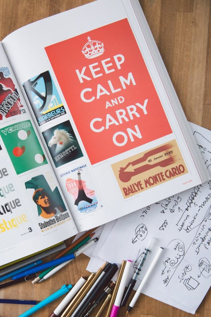 keep calm and carry on magazine Artistic desk setup features graphic design book and tools, inspiring creativity.